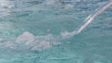 un chorro de agua se vierte en una piscina a medida que se llena