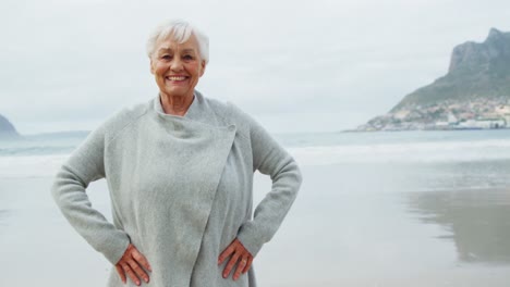 Portrait-of-senior-woman-standing-on-beach