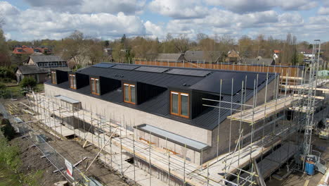 drone slowly flying towards rooftop with solar panels of new houses under construction