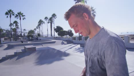 a bmx bike rider puts on a helmet and looks over a skatepark