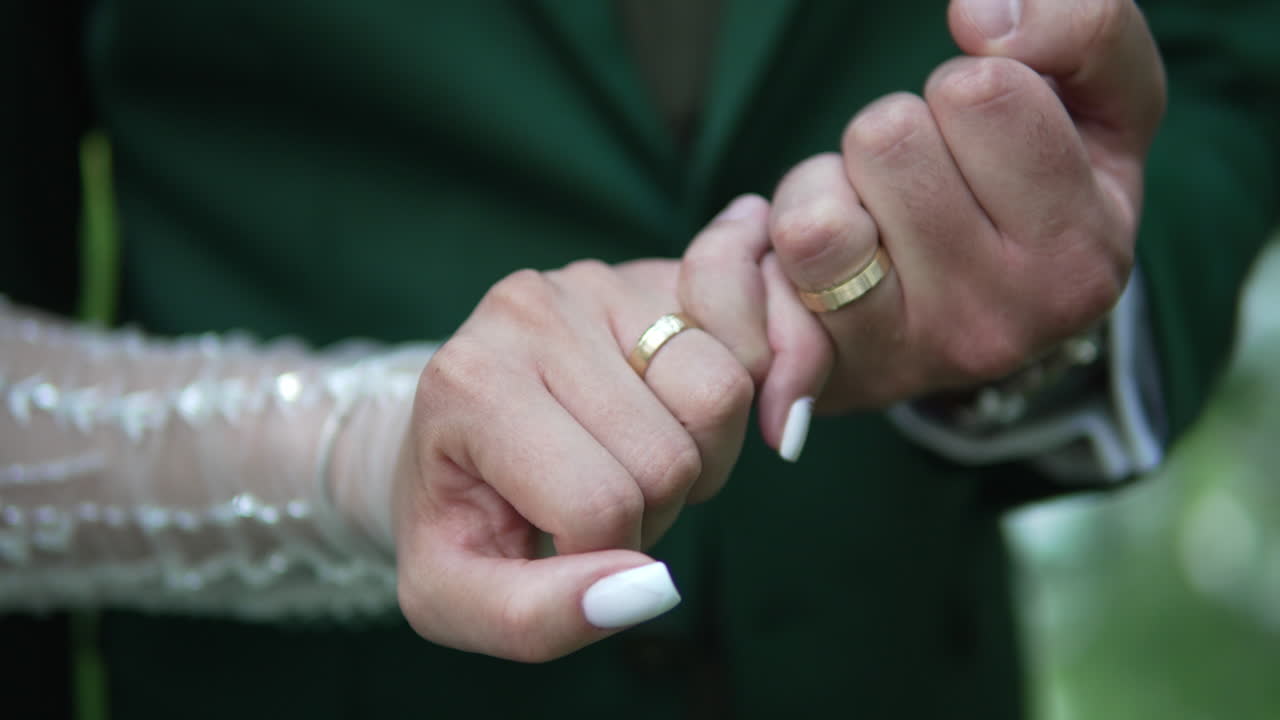 celebrar un momento romántico del día de la boda mientras la novia y el novio se toman de la mano, mostrando sus anillos de boda y el profundo vínculo de amor y compromiso