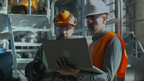 factory engineers reviewing data on laptop