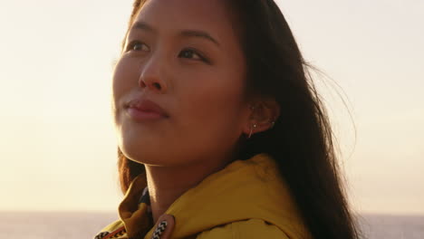 portrait of beautiful asian woman enjoying seaside at sunset exploring spirituality looking up praying contemplating journey relaxing on beach