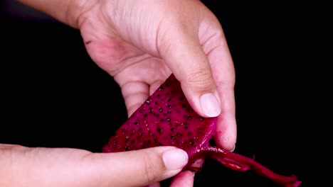 hands peeling a vibrant dragon fruit slice