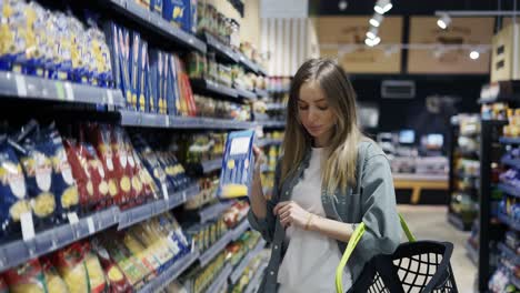 Girl-buyer-chooses-products-in-the-store.-Daily-trip-to-the-store.-Purchase