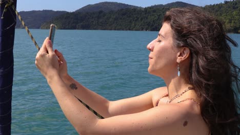 hermosa mujer haciendo un selfie en un barco en movimiento