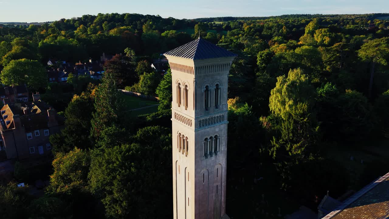 Droneopptak av den historiske St. Mary og St. Nicholas kirke i Wilton nær Salisbury, Wiltshire, England. Opptaket avslører det karakteristiske klokketårnet i kampanile-stil omringet av trær og det engelske.
