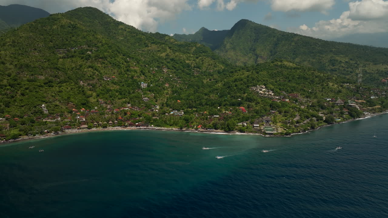 Aerial View of Tropical Coastline Village with Lush Mountains and Ocean