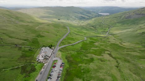 kirkstone pass busy summit with full car park and view down to lake windermere. summer., lake district, cumbria, uk