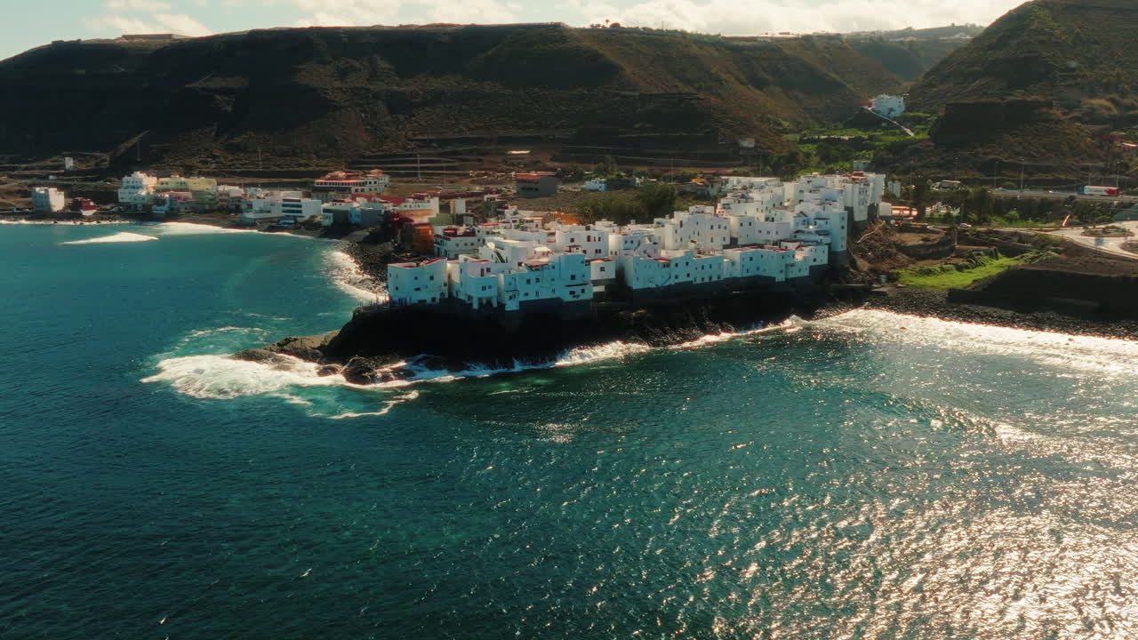 Pan drone shot of Tejeda town located in between ocean and hills in Gran Canaria, Spain.
