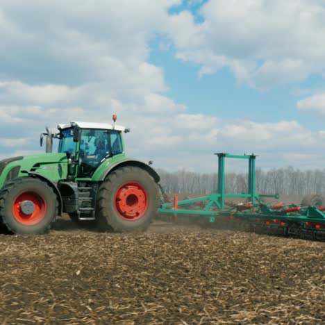 agronegocios - tractor corriendo en el campo en primavera