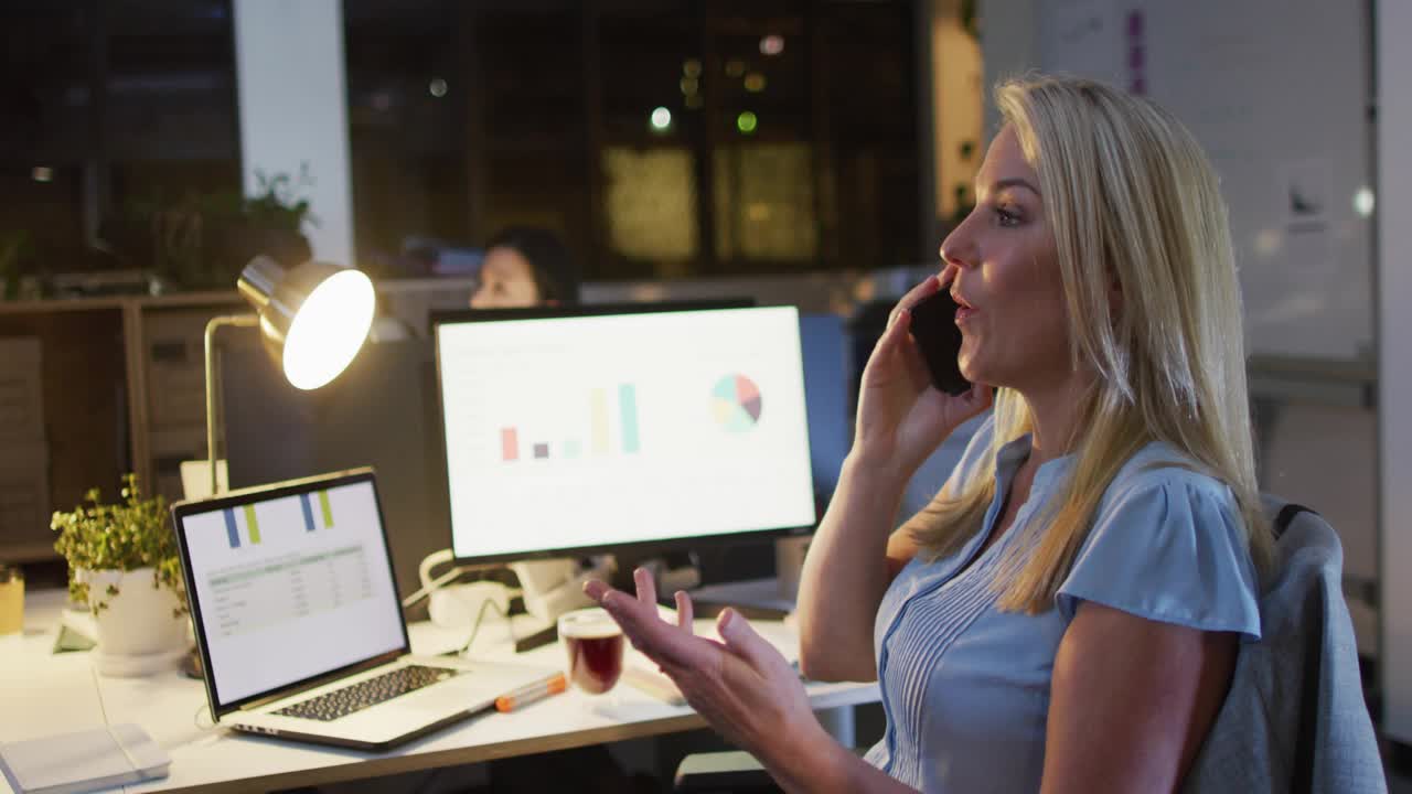 Office manager speaking on phone, call causing social media badges growing while monitoring charts