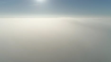 flight over misty clouds in morning sunlight with little glory and city scape under clouds