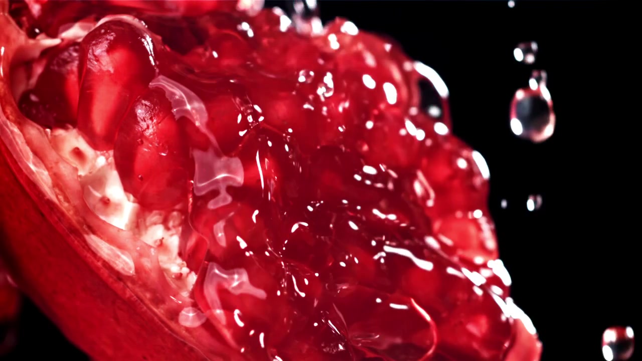 Slow Motion Water Drops on Fresh Red Pomegranate Seeds