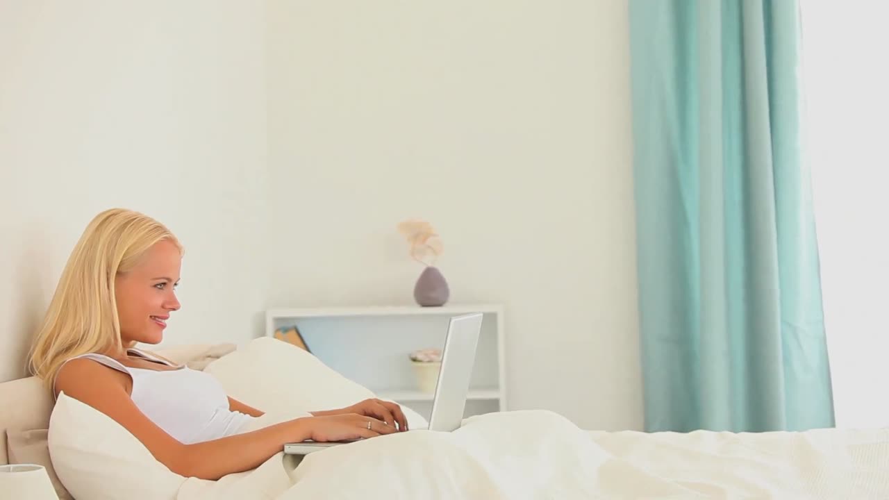 침대에 노트북을 든 여자