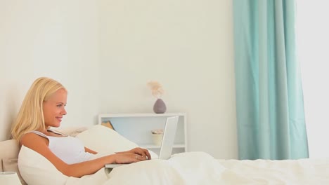frau mit einem notizbuch in ihrem bett