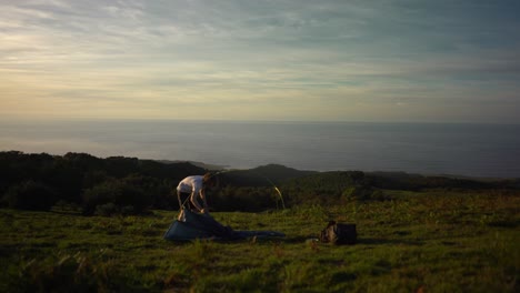 Excursionista-Lanzando-Una-Carpa-Con-Vista-Al-Mar-Al-Atardecer