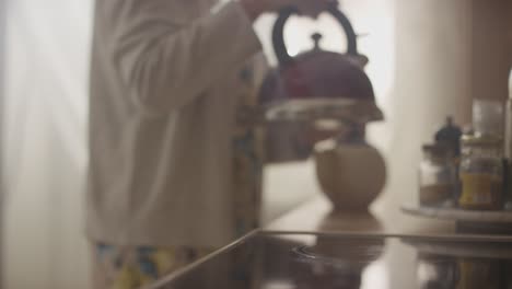 woman preparing tea or coffee in kitchen