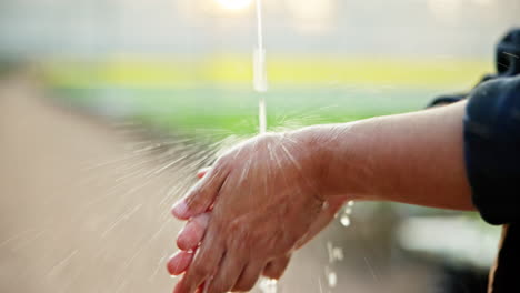 person washing hands outdoors
