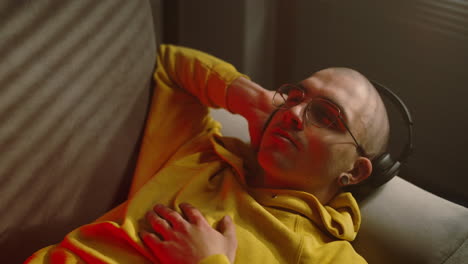 young man listening to music on a couch