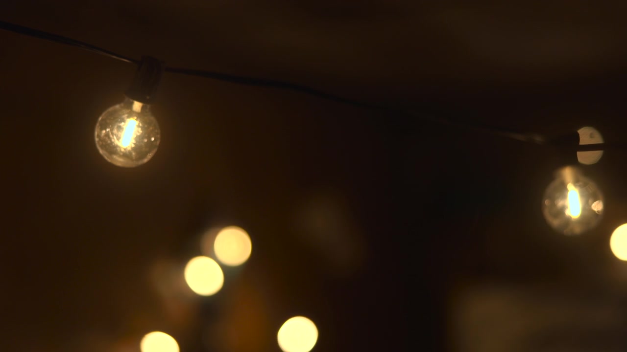 Lampu Hias Tali Berpijar dengan Bokeh Lembut, Suasana Pesta Kebun Luar Ruangan dengan Bola Cahaya Kuning Hangat, Dekorasi Malam yang Intim