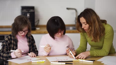 Dos-Niñas-Con-Discapacidad-Dibujan-En-Casa-Junto-A-La-Maestra