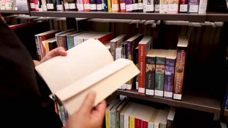 person selecting and reading a book