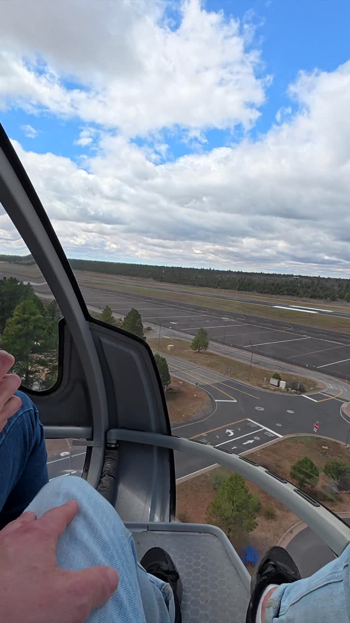 Punto di vista del passeggero: elicottero che decolla sopra la pista dell'aeroporto