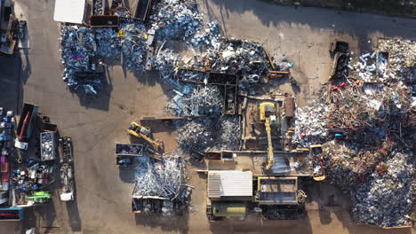 Recycling-landfill-scrap-yard-with-excavators-sunny-day-aerial-top-shot