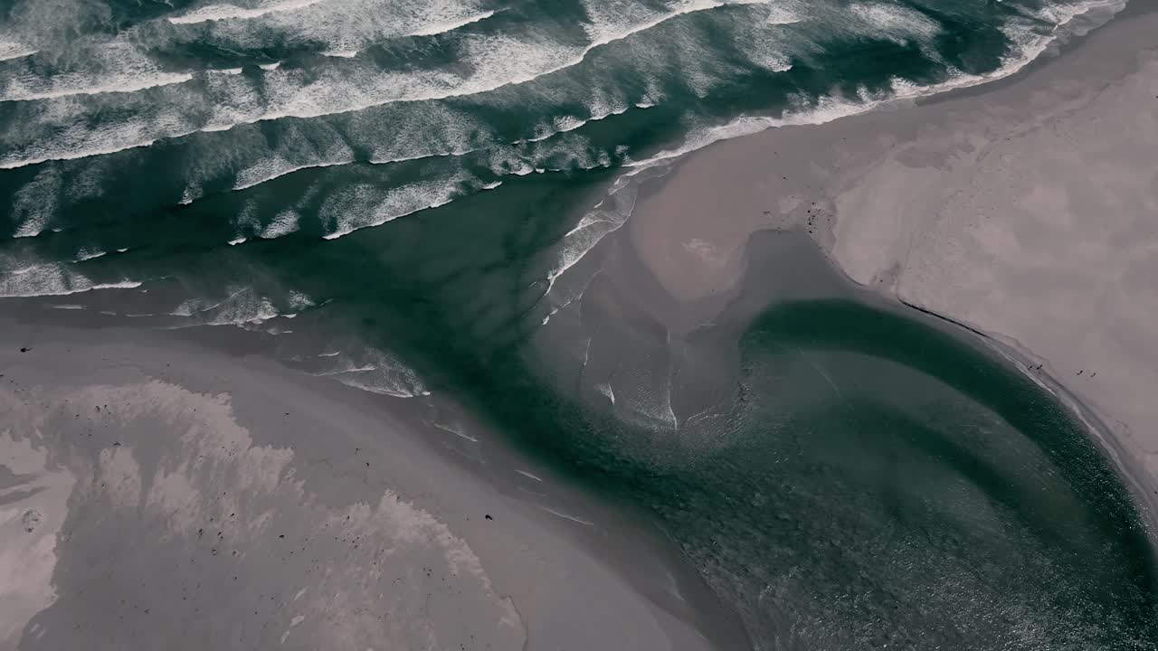 Ocean waves flowing into a lagoon mouth coastal estuary at high tide