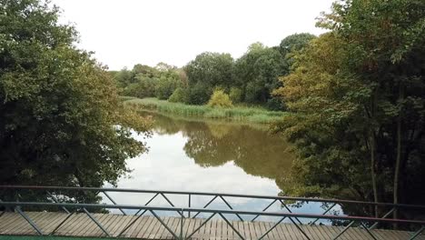 drone flying over a small bridge in a park