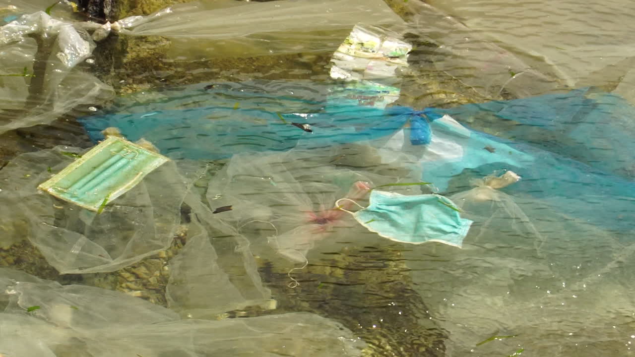 plásticos no reciclables y máscaras en aguas de playa