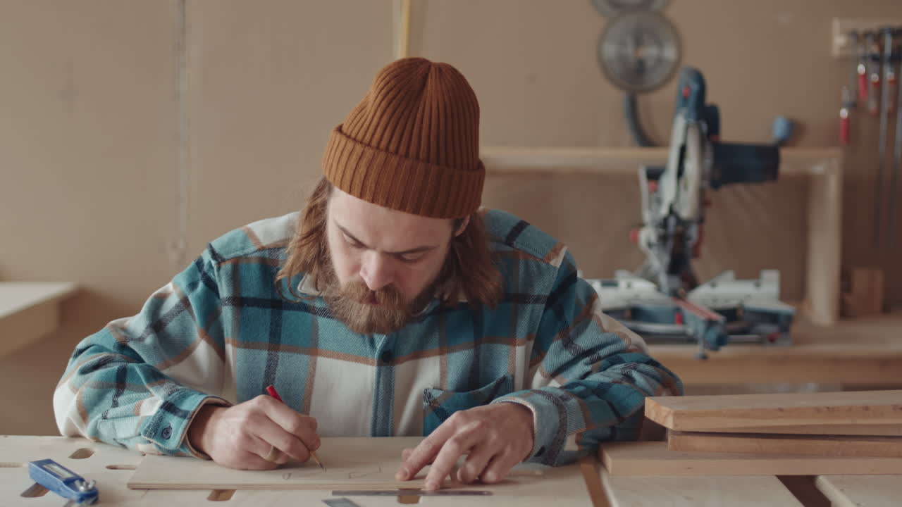 Male Caucasian Carpenter Drawing on Wooden Board
