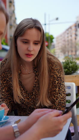 two young women having a conversation in a cafe
