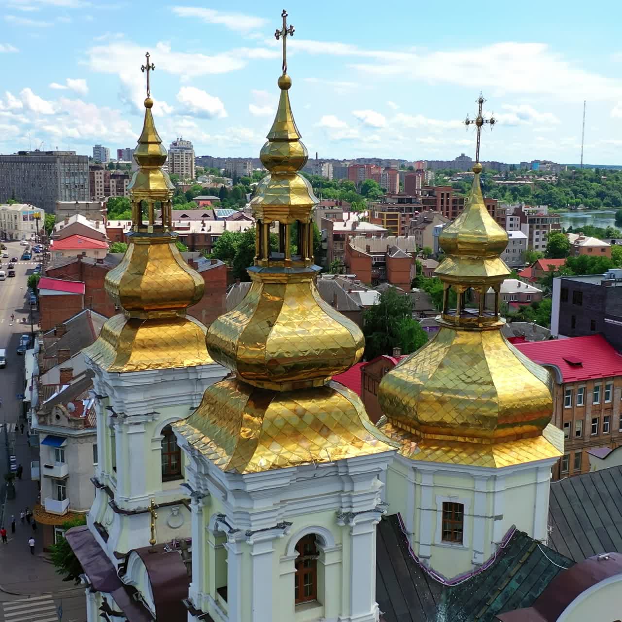 Descending over the stunning Christian church with golden cupolas. Orthodox cathedral in the city downtown. Ukraine, Vinnytsia. Top view