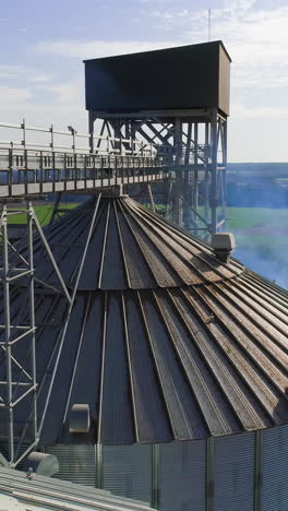 grain warehouse, granary. large steel towers for storing crops. large animal feed factory. aerial view. vertical video