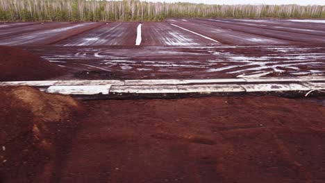 vista aérea lateral que revela el sitio de la mina de depósito de turba en medio de un bosque