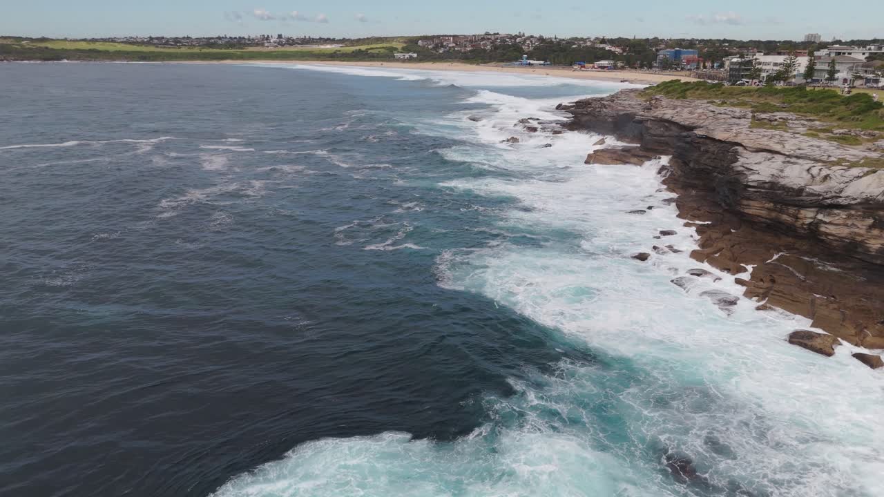 Drone Flying Over Ocean Toward Maroubra Beach, Eastern Sydney Suburb – Crashing Waves on Rocks and Shoreline, Australia Coastal Aerial Stock Footage