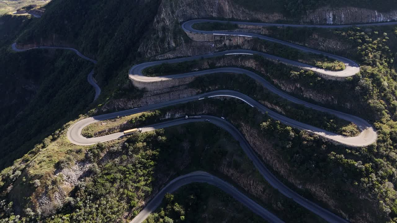 aerial of Leba Pass, Angola, ars driving along the twisting road of Leba Pass in southern Angola, surrounded by majestic mountain landscapes