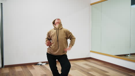 woman exercises posture with hoodie rap dance near mirrors indoor