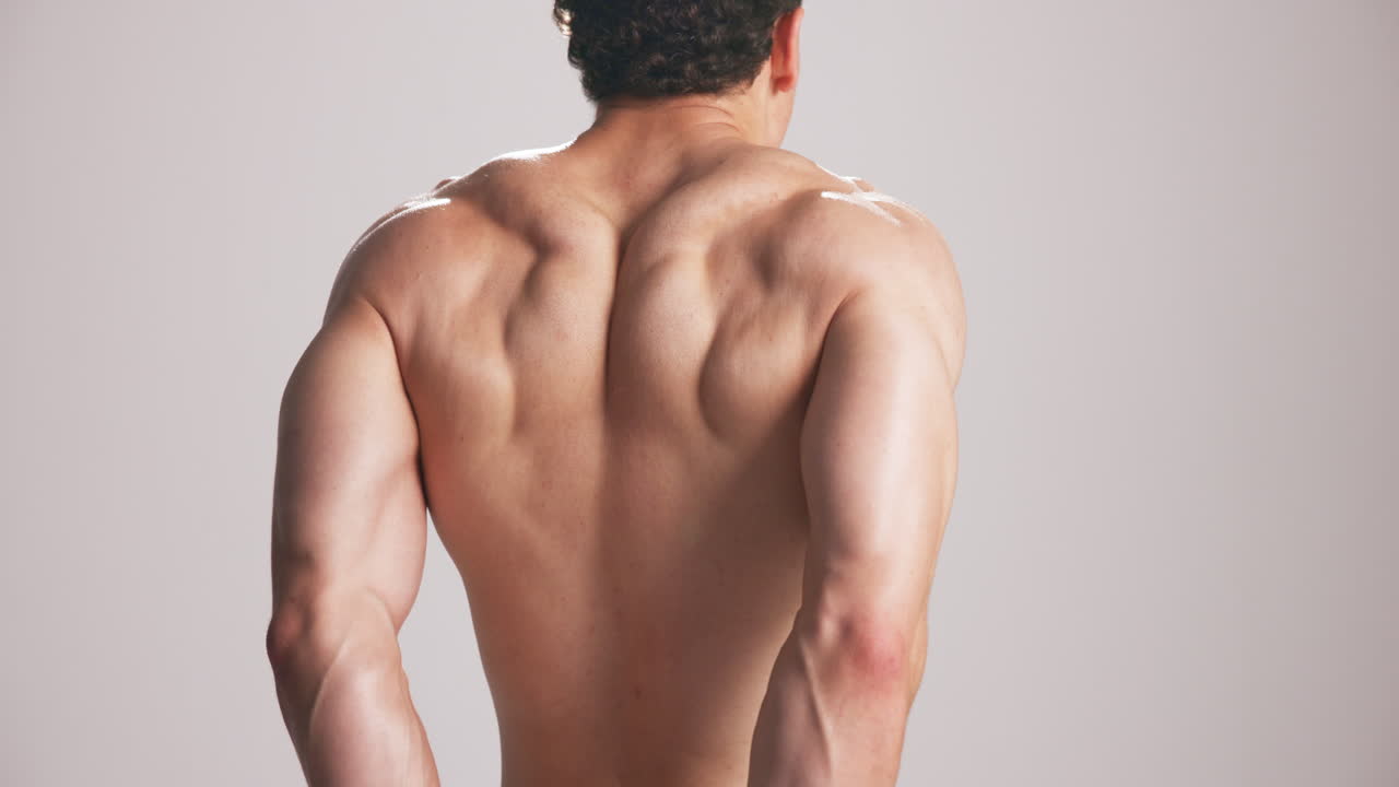 Muscular Man Flexing Back Muscles on White Background