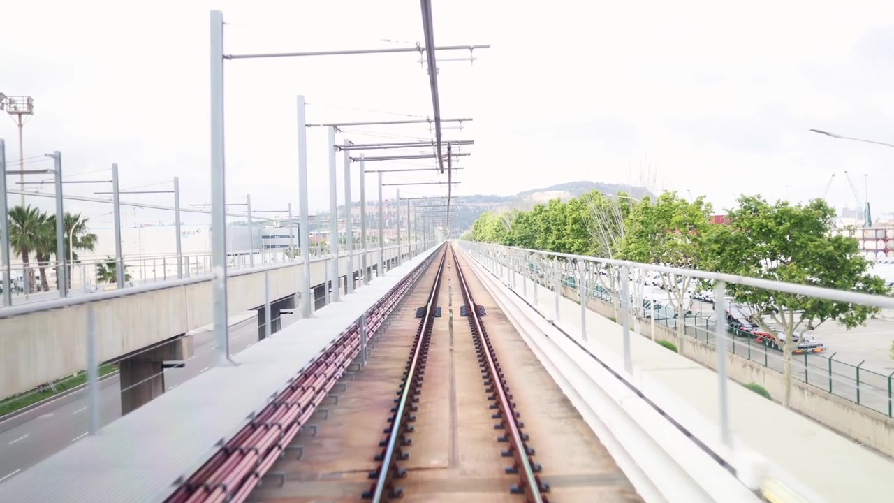 都市の景観の中を高架線路を走行する列車のPOVショット