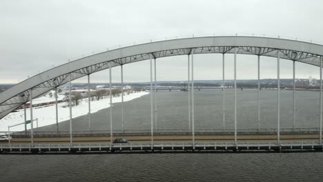 toma aérea de seguimiento de un automóvil que cruza el puente centenario que conecta las ciudades cuádruples en illinois e iowa
