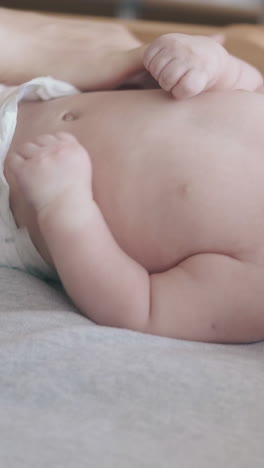 professional pediatrician turns infant along baby changing table and newborn boy starts crying close view