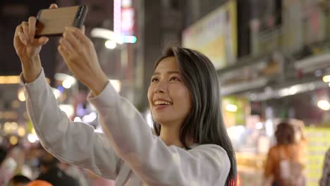 happy young asian woman using smart phone in  night market