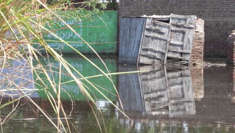 Paisaje-Inundado-Con-Edificio-De-Ladrillo-En-Segundo-Plano-En-Sindh,-Pakistán