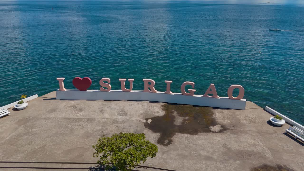 un cartel de bienvenida en el bulevar surigao del norte junto al mar azul