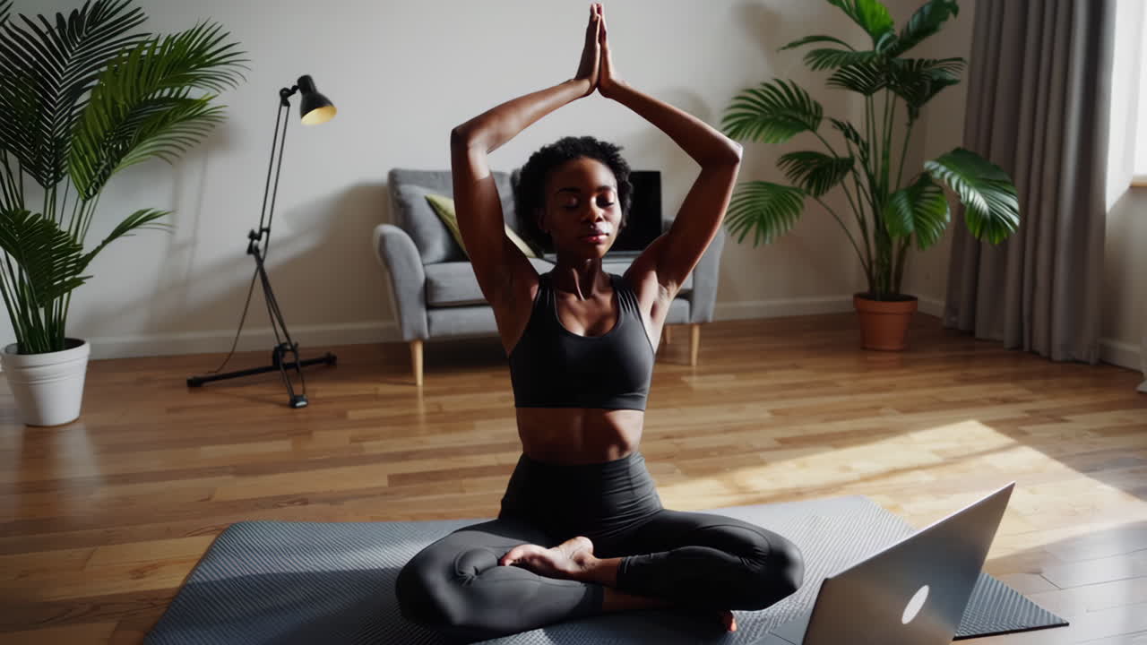 Kvinna mediterar och utövar yoga hemma