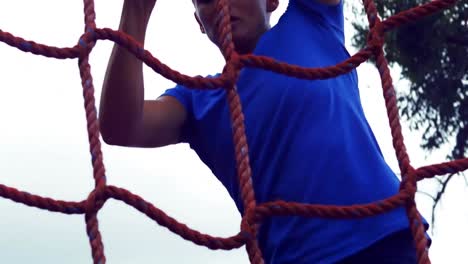 woman climbing the net during obstacle course