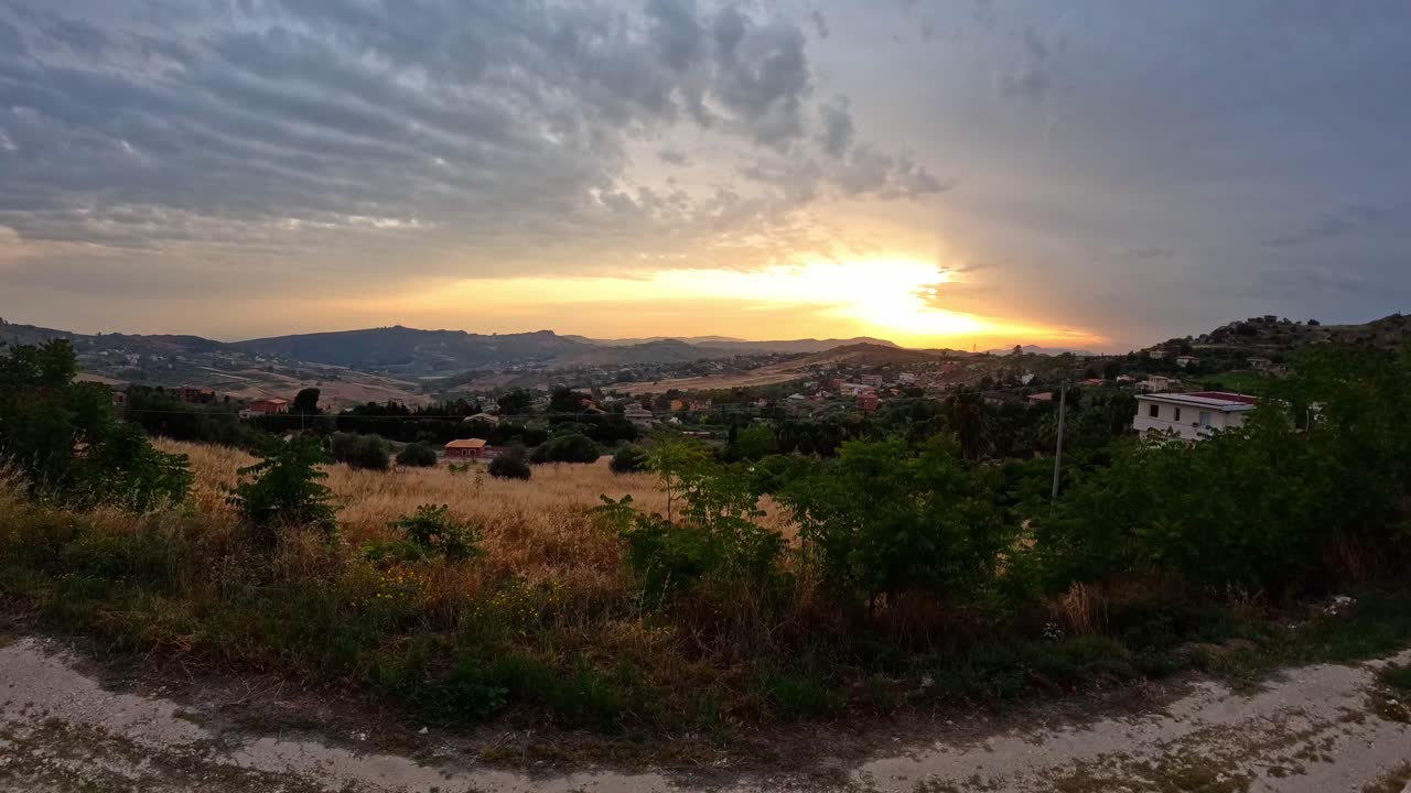 Time lapse della campagna siciliana al tramonto nuvoloso, Italia.